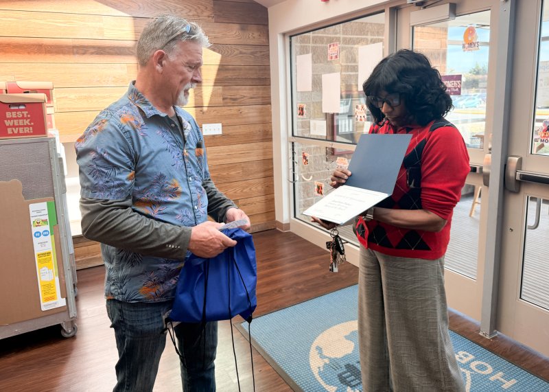 Tanny Dickerson, right, Connecting Generations director of mentoring programs, presents Jon Fisher with a goody bag and a certificate.